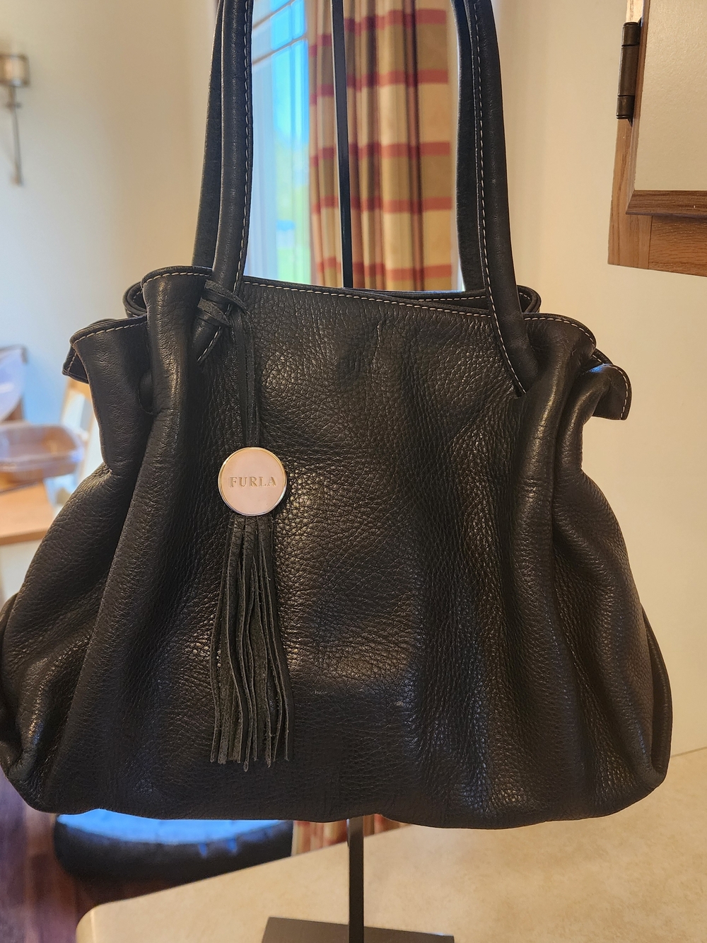 black leather tote bag from Furla, featuring a distinct tassel charm